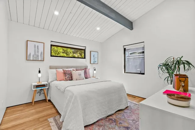 a bedroom with bed and painting on the wall