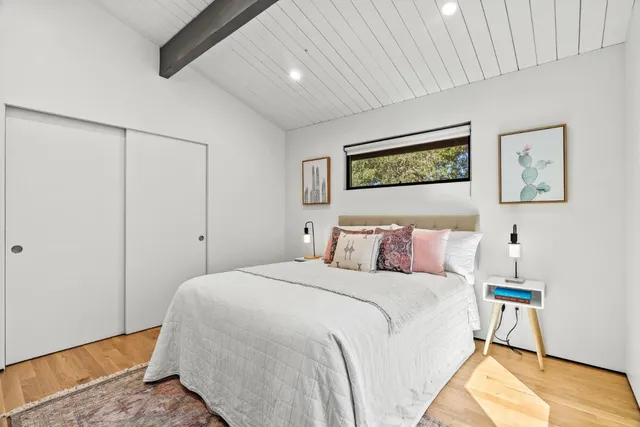 a bedroom with a bed and a painting on the wall