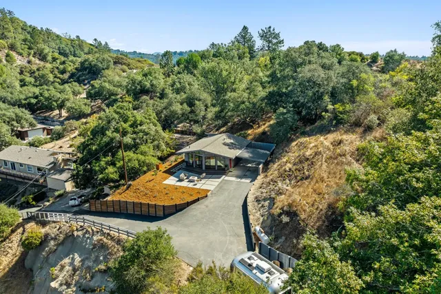 an aerial view of a house with a yard and lake view