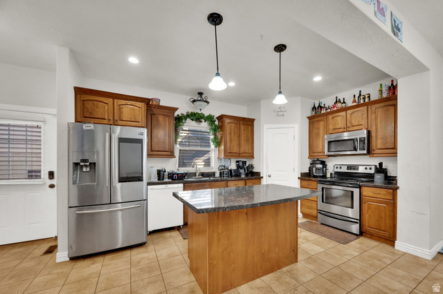 2026 Cres Drive South Mapleton, UT 84664 - Photo 4 of 18 Kitchen featuring stainless steel appliances, decorative light fixtures, wood finish cabinets, and light tile patterned floors
