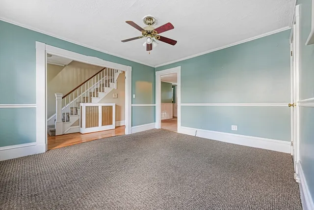 an empty room with ceiling fan and windows
