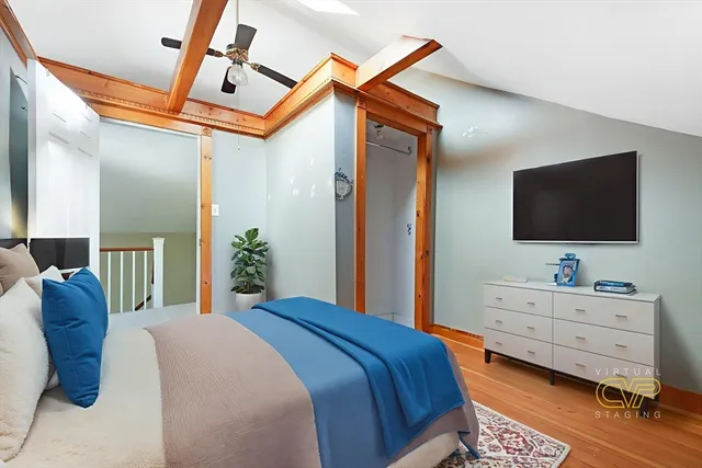 a bedroom with a bed and a flat tv screen on dresser