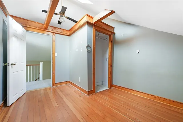 a view of a room with wooden floor and a ceiling fan