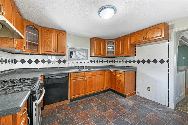 a view of a kitchen with stainless steel appliances granite countertop a stove a sink and a refrigerator