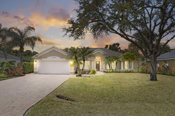 front view of a house with a yard and trees