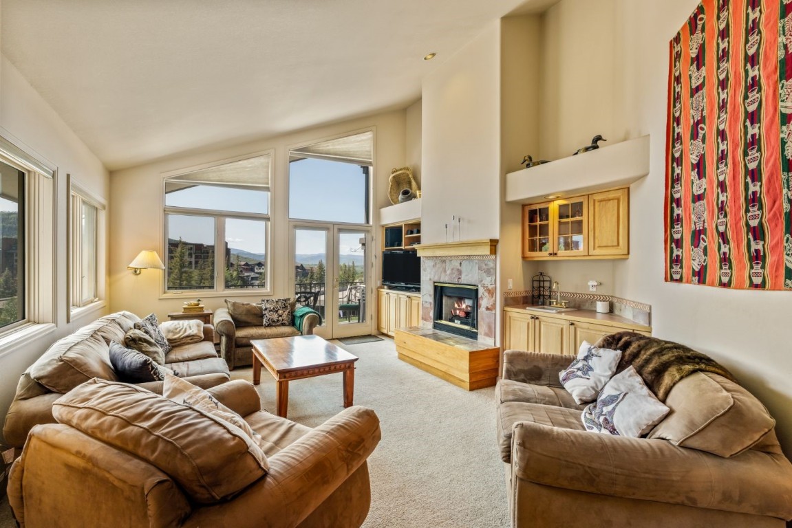 1724 Ski Time Square Drive, Unit R5 Steamboat Springs, CO 80487 - Photo 2 of 19 Living area featuring light colored carpet, plenty of natural light, a high end fireplace, and high vaulted ceiling
