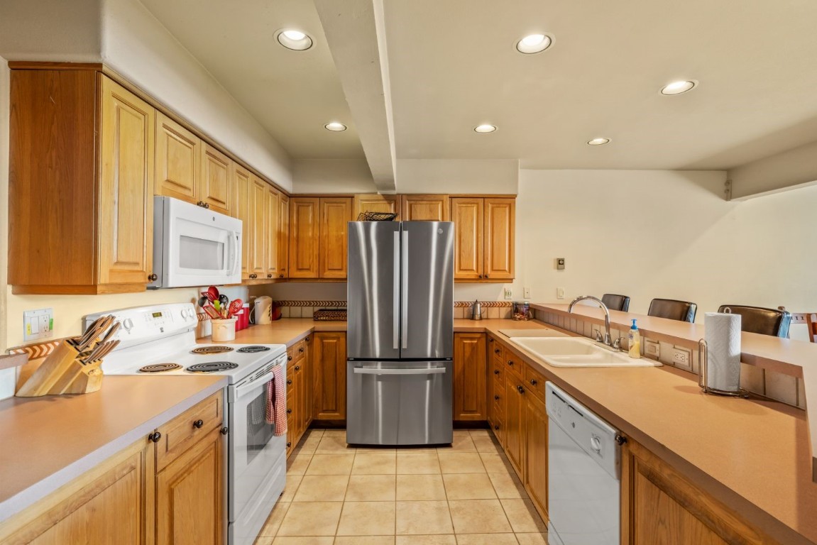 1724 Ski Time Square Drive, Unit R5 Steamboat Springs, CO 80487 - Photo 8 of 19 Kitchen featuring white appliances, a sink, light tile patterned floors, recessed lighting, and light countertops