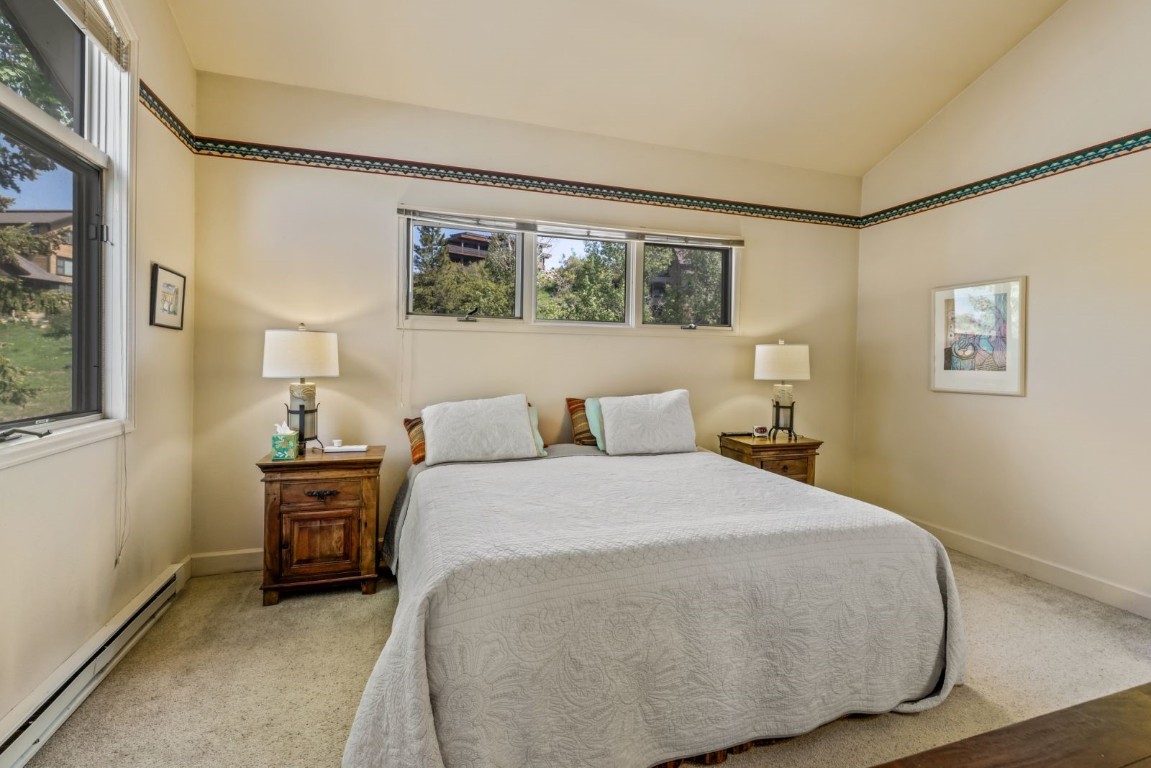 1724 Ski Time Square Drive, Unit R5 Steamboat Springs, CO 80487 - Photo 9 of 19 Bedroom with a baseboard heating unit, multiple windows, carpet floors, and lofted ceiling