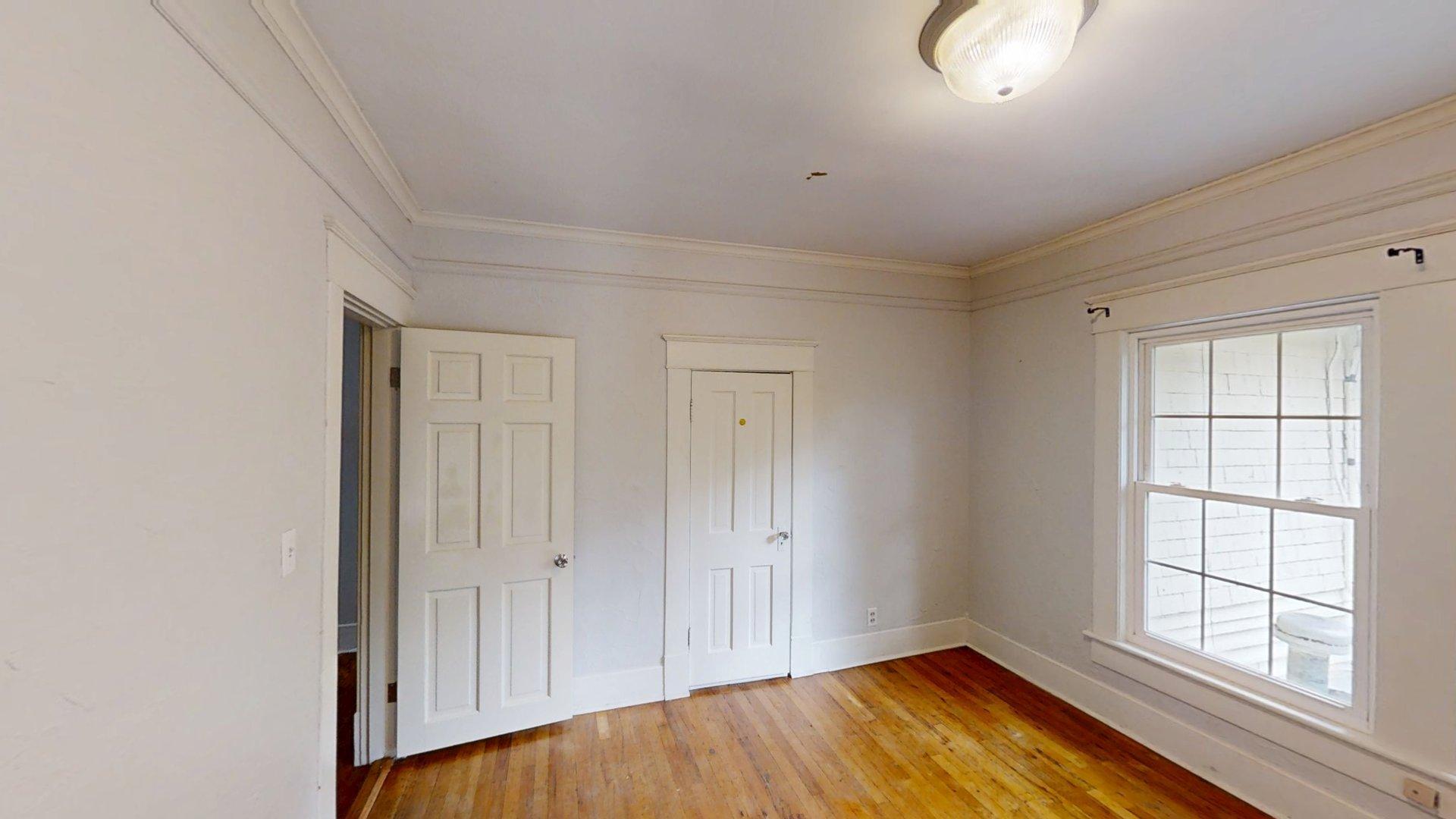 219 F Street Southwest Ardmore, OK 73401 - Photo 29 of 58 Hardwood flooring, crown molding, white trim, recessed panel doors, and a double-hung window