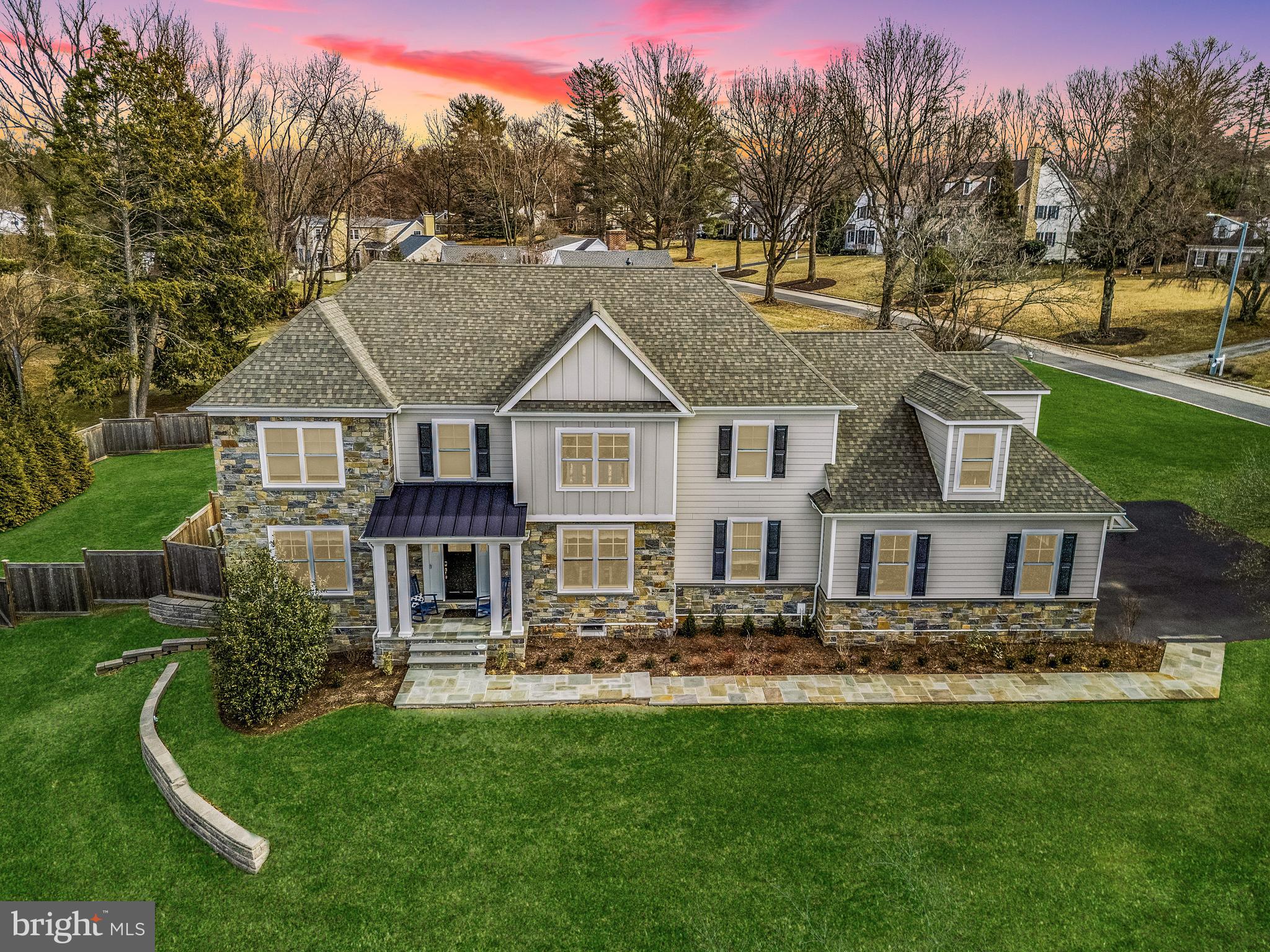 a front view of a house with lots of trees and plants