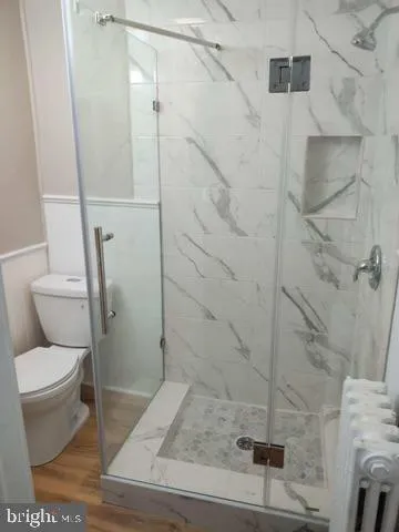 a bathroom with a toilet and a shower
