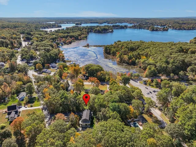 a kitchen with kitchen island stainless steel appliances a table chairs sink and wooden floor