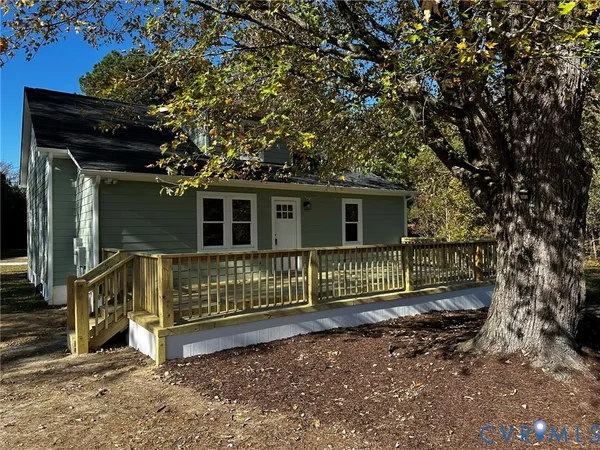 a view of a house with a small yard and wooden fence