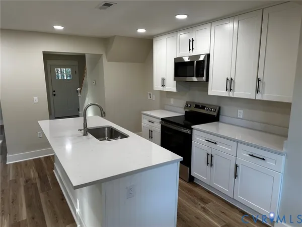 a kitchen with a sink a microwave and cabinets