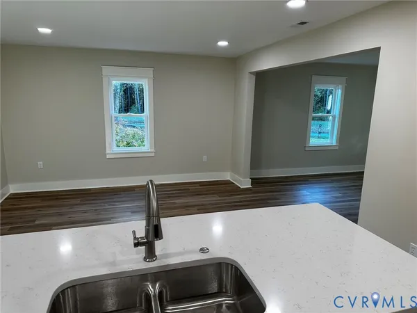 a kitchen with a sink and wooden floor