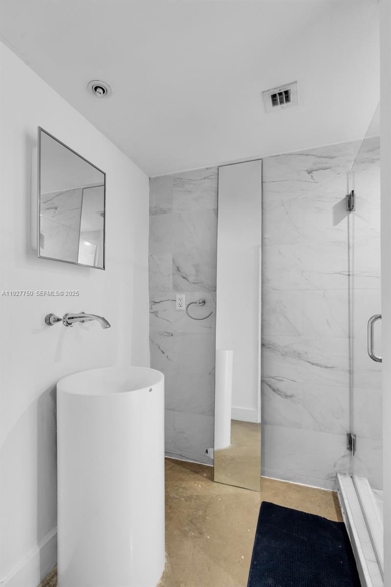 5701 Biscayne Boulevard, Unit PH9 Miami, FL 33137 - Photo 29 of 40 a bathroom with a sink a toilet and shower