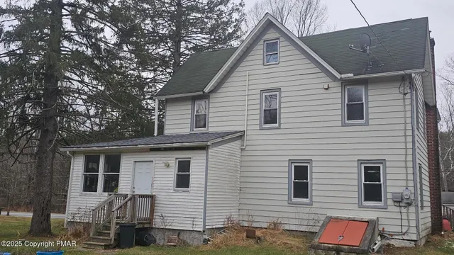 a front view of a house with a tree