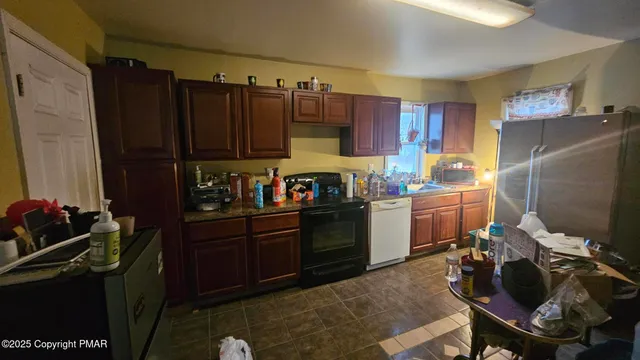 a kitchen with a refrigerator and a stove top oven