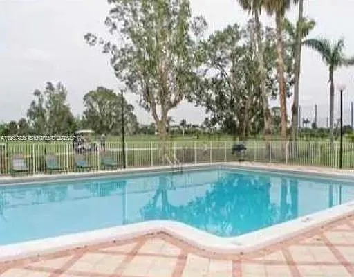 a view of a swimming pool and trees in the background