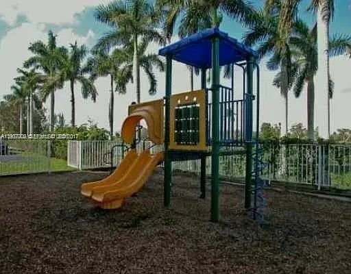 a view of a wooden deck with a table and chairs under an umbrella