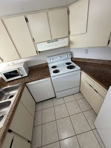 a kitchen with a stove top oven and cabinets