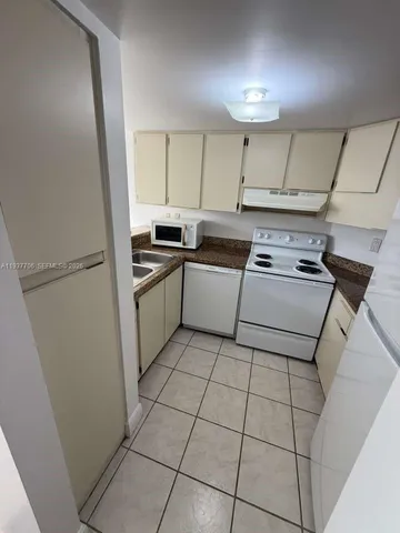a kitchen with a stove top oven and cabinets