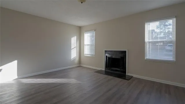 a view of a kitchen from the hallway with a chair and wooden floor