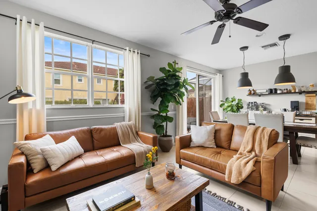 a living room with furniture ceiling fan and a window