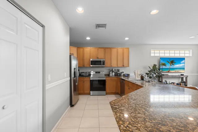 a large kitchen with a large counter top stainless steel appliances and cabinets