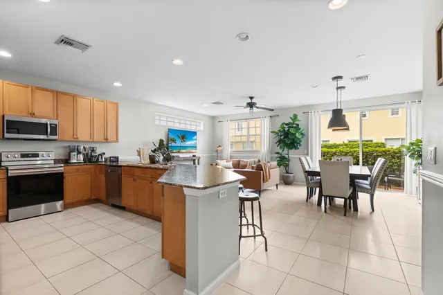 a kitchen with stainless steel appliances kitchen island granite countertop a table and chairs in it
