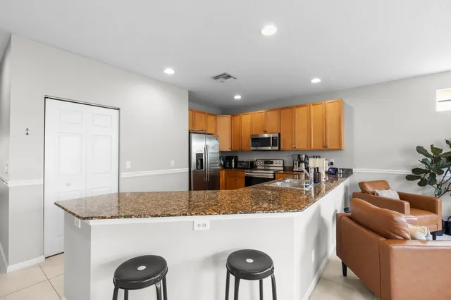 a kitchen with granite countertop a counter top space a sink stainless steel appliances and cabinets