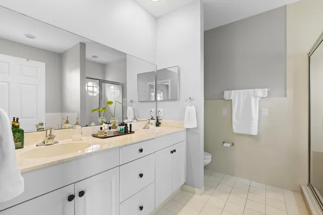 a bathroom with a double vanity sink mirror and toilet