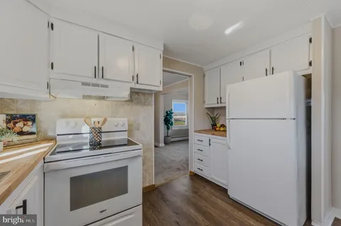 a kitchen with white cabinets and white appliances