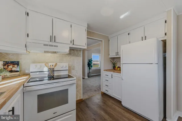 a kitchen with white cabinets and white appliances