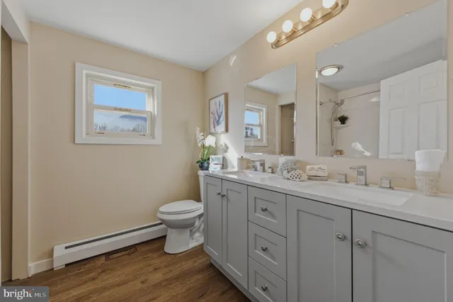 a bathroom with a granite countertop toilet sink and a mirror
