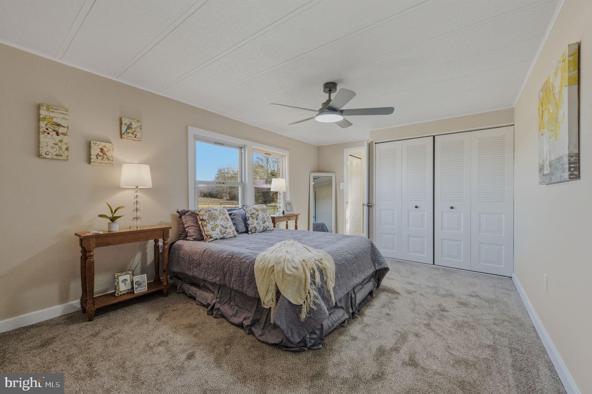 946 Vandyke Greenspring Road Townsend, DE 19734 - Photo 22 of 32 a spacious bedroom with a bed and a chandelier