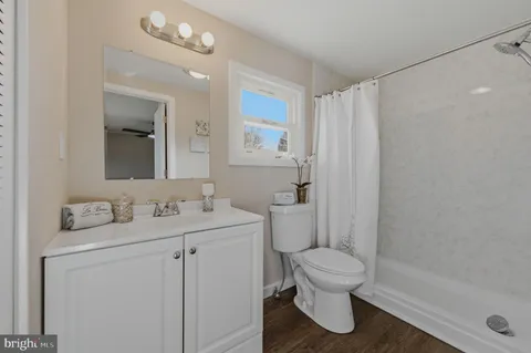 a bathroom with a granite countertop sink toilet a mirror and shower