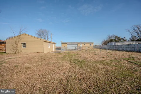 a view of a house with backyard and trees