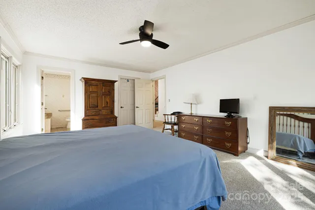 a spacious bedroom with a bed and dresser