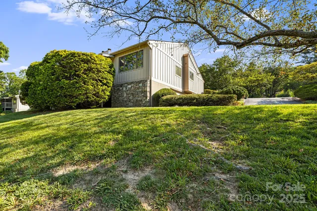 a front view of a house with a yard and potted plants