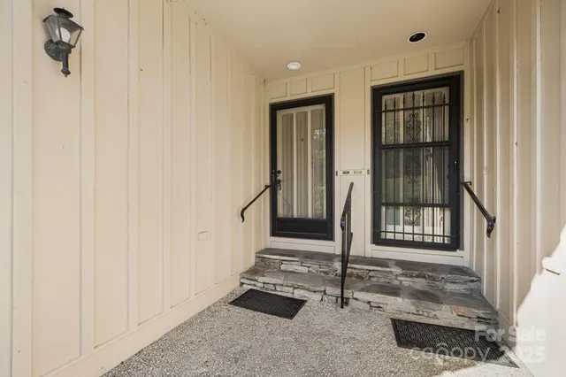 a view of a backyard with plants and large trees