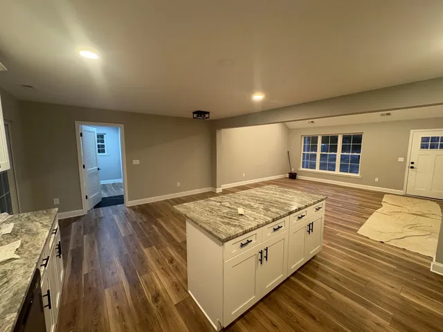 a kitchen with stainless steel appliances granite countertop a stove and a wooden floors