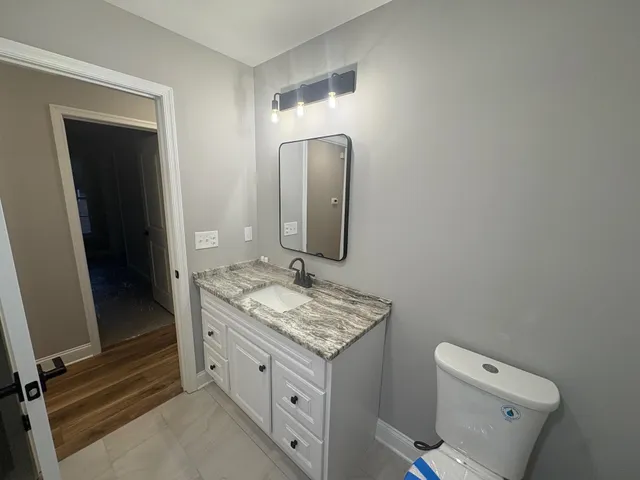 a bathroom with a granite countertop sink and a mirror