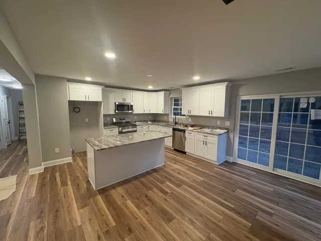 a large kitchen with kitchen island a sink stainless steel appliances and cabinets