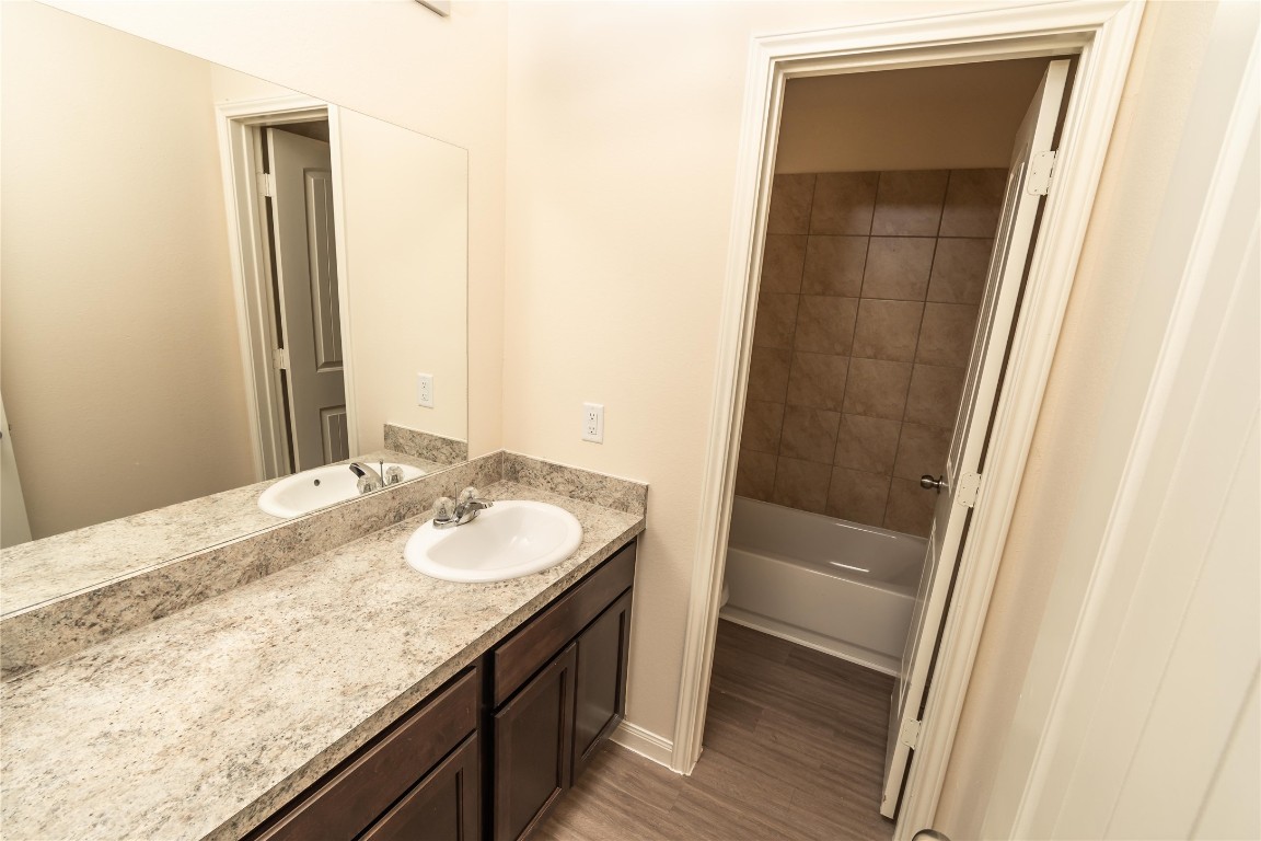 4259 Silver Ranch Road Houston, TX 77014 - Photo 9 of 9 a bathroom with a granite countertop sink and a mirror