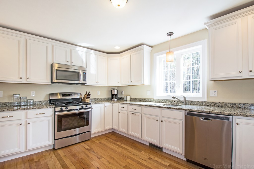 42 White Pond Road Stow, MA 01775 - Photo 8 of 26 a kitchen with granite countertop white cabinets and appliances