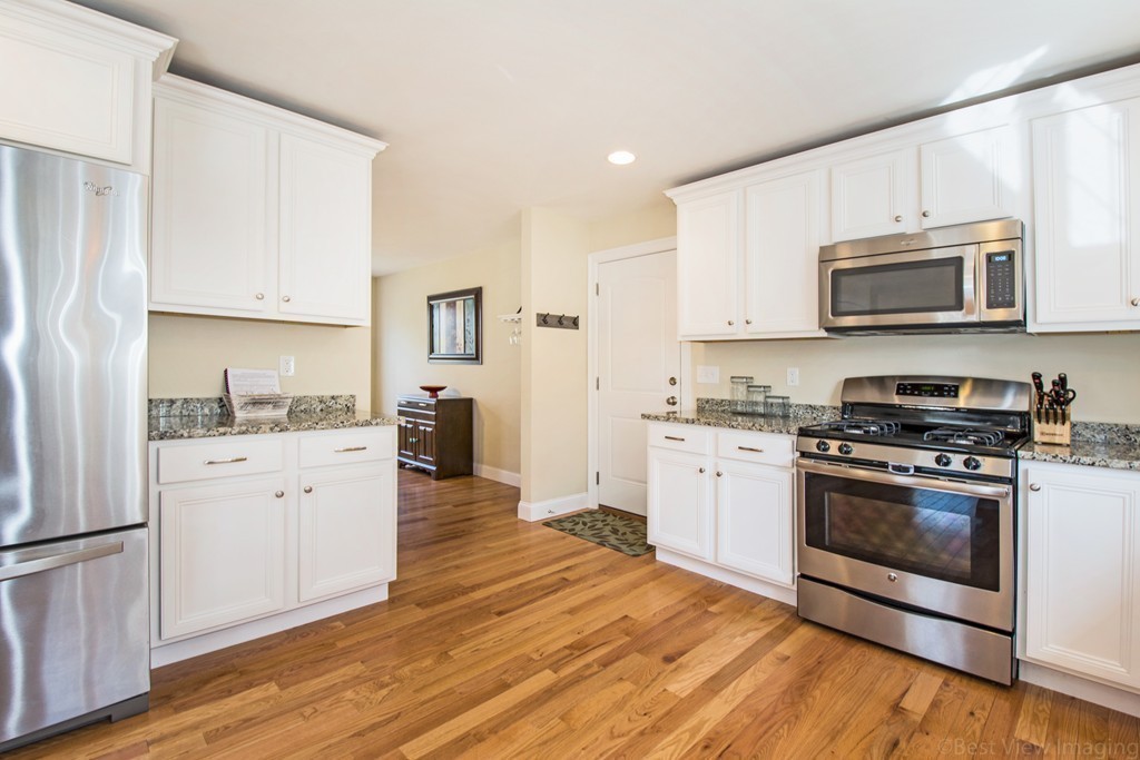 42 White Pond Road Stow, MA 01775 - Photo 10 of 26 a kitchen with granite countertop white cabinets and stainless steel appliances