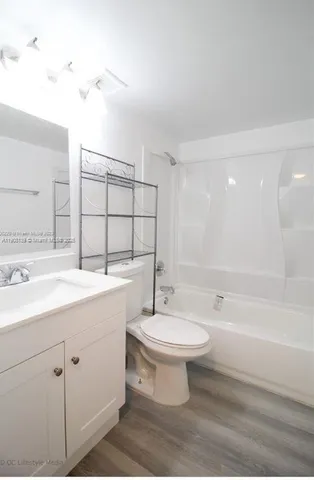 a bathroom with a sink toilet a mirror and shower