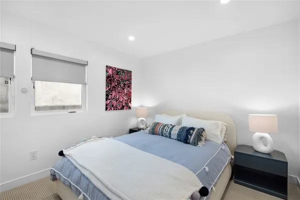 a bedroom with a bed and a lamp on dresser
