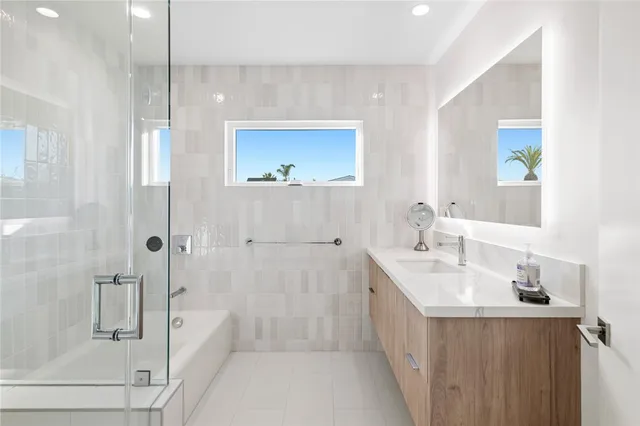 a bathroom with a double vanity sink mirror and shower